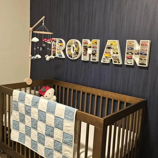 Custom name toy car display shelf with the name Roman mounted on a nursery wall for Hot Wheels cars